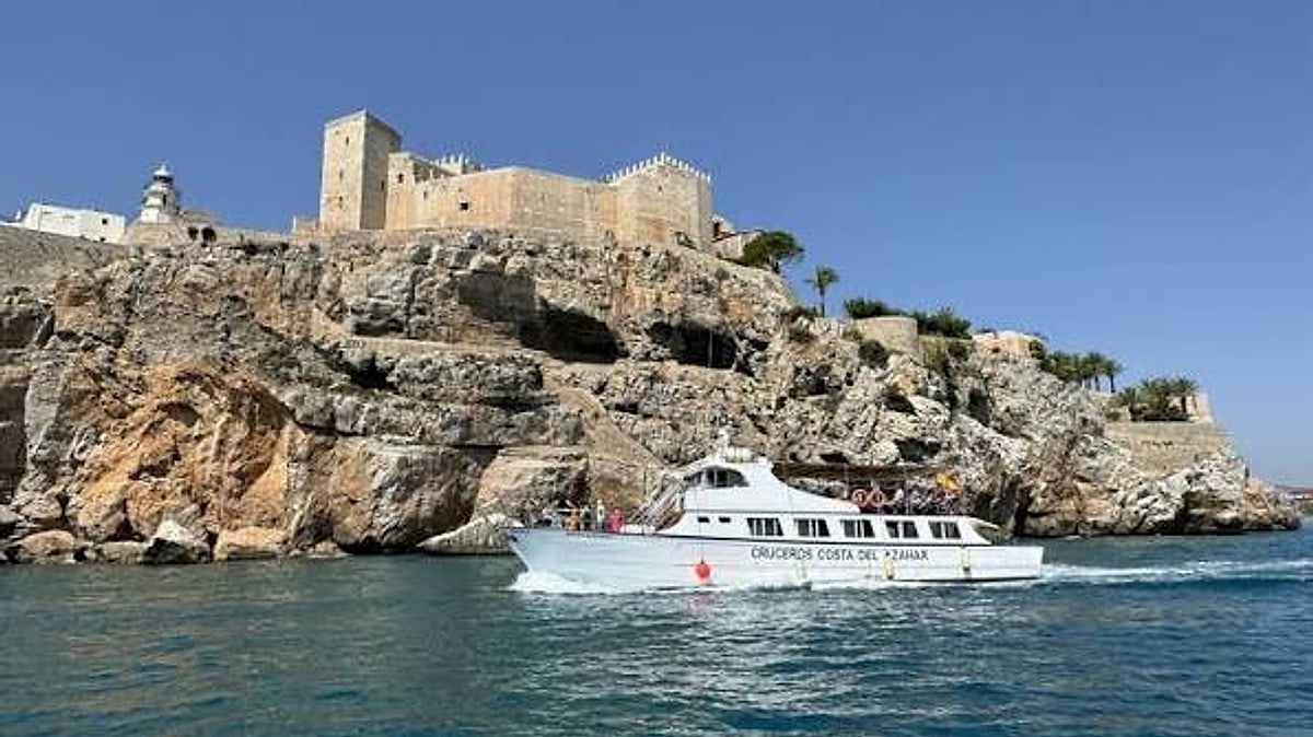 Barco de recreo navegando al pie del Castillo del Papa Luna de Peñíscola