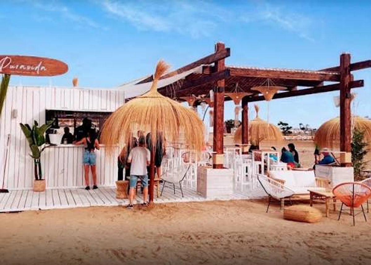 Terraza de un chiringuito a pie de playa en Peñíscola con sombrillas de paja